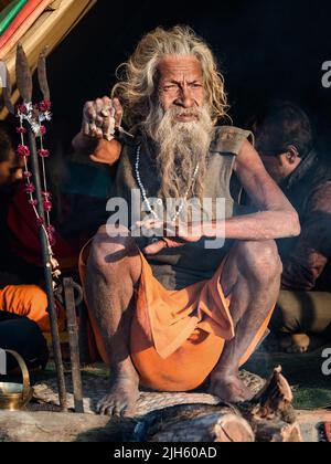 L'uomo santo indiano Amar Bharati Urdhavaahu, che ha tenuto il suo braccio sollevato per oltre 40 anni in onore del Dio indù Shiva, al Festival Kumbh Mela in India. Foto Stock