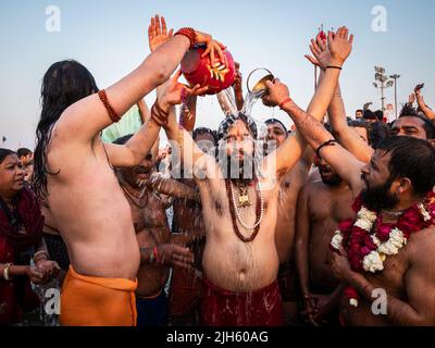 I fedeli indù pregano e fanno il bagno nelle acque sacre del Triveni Sangam con migliaia di altri devoti al Kumbh Mela Festival in India. Foto Stock