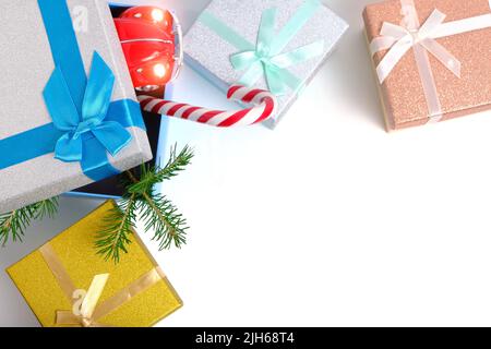 Scatole regalo di Natale con regali, con albero di Natale verde e caramello su sfondo bianco Foto Stock