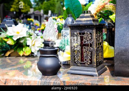 Candele commemorative in un tipico cimitero polacco cattolico romano (Cmentarz na Solipsach, cimitero parrocchiale di Ursus, Varsavia, Polonia) Foto Stock