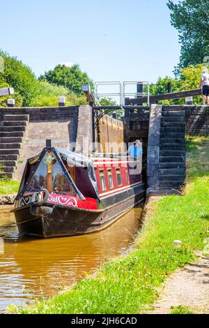 Uomo e donna su un canale narrowboat vacanza dopo aver attraversato blocco 65 Wheelock top lock, sul canale Trent e Mersey a Wheelock Cheshire Foto Stock