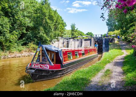 Uomo in una vacanza sul canale in barca stretta dopo aver attraversato la chiusa 65 Wheelock top lock, sul canale Trent e Mersey a Wheelock Cheshire Foto Stock