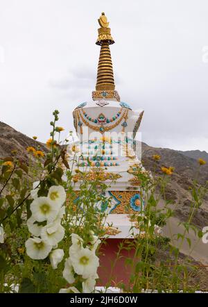 Choerten decorato con fiori e catene, Thiksey Gompa, Ladakh, India Foto Stock