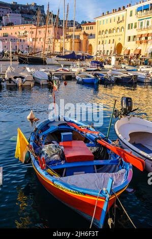 Piccola barca a remi colorata per la pesca, barca dipinta di blu rosso con remi rossi, porto di Portoferraio, Elba, Toscana, Italia Foto Stock