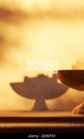Primo piano di candela illuminata, un simbolo di speranza, verità o spirituale in ottone sostegno illuminazione e illuminazione casa oscura con spazio copia. Decorazioni antiche Foto Stock