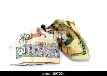 Crumpled rugged American money note di 20 $ venti dollari fattura e 20 LE venti egiziano banconote in contanti isolato su sfondo bianco, econom Foto Stock