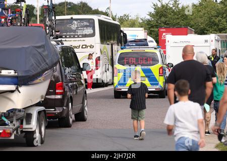 Ratingen, Germania. 16th luglio 2022. Un veicolo di polizia guida un'auto con un rimorchio per imbarcazioni all'uscita dell'autostrada 3 vicino Ratingen e all'area di servizio Hösel. La polizia utilizza il punto intermedio della vacanza estiva come opportunità per controlli sul traffico a livello nazionale. Credit: David Young/dpa/Alamy Live News Foto Stock