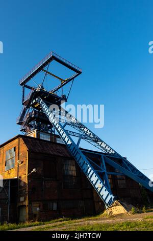 La torre di albero di una miniera chiusa di carbone nero. I processi di decarbonizzazione nel mondo moderno durante la crisi energetica Foto Stock