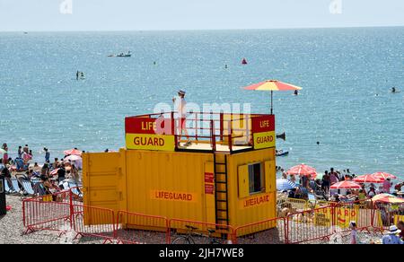 Brighton UK 16th luglio 2022 - Una guardia di vita tiene sotto controllo la spiaggia di Brighton, che è impanata come le folle godono il caldo sole oggi, ma un avvertimento di tempo rosso estremo è stato emesso per la prima parte della prossima settimana: Credit Simon Dack / Alamy Live News Foto Stock