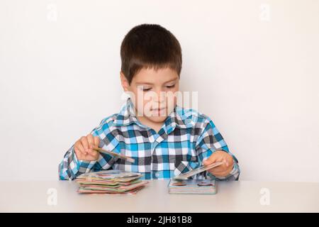 Un ragazzo di 4 anni gioca con carte con immagini, materiale didattico per bambini in età prescolare. Foto Stock