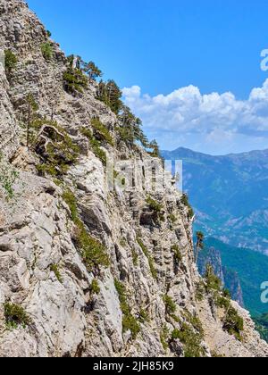 Scogliere calcaree a strapiombo sull'abisso oltre Drakolimni il Lago del Drago sul Monte Timfi nelle Montagne del Pindus Grecia guardando verso il Monte Trapezitsa Foto Stock