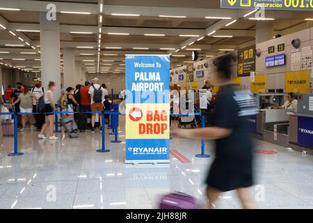 Palma, Spagna. 16th luglio 2022. I viaggiatori aspettano all'aeroporto allo sportello della compagnia aerea Ryanair per effettuare il check-in dei bagagli. Il fine settimana (16./17.07.2022) presso l'aeroporto di Maiorca saranno più voli che prima della pandemia. Credit: Clara Margais/dpa/Alamy Live News Foto Stock