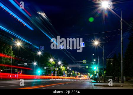 vista sulla strada centrale della città notturna con la luce luminosa delle luci della strada di illuminazione serale con indicazioni stradali informative Foto Stock