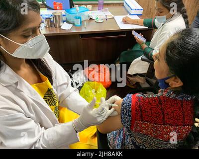 Bangalore, India. 16th luglio 2022. Un operatore sanitario inocula una donna con una dose di richiamo del vaccino COVID-19 a Bangalore, India, 16 luglio 2022. Il governo indiano venerdì ha iniziato un viaggio speciale di 75 giorni per somministrare COVID-19 dosi di richiamo a tutti gli adulti di età superiore ai 18 anni. Credit: Str/Xinhua/Alamy Live News Foto Stock