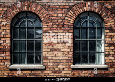 Un paio di finestre ad arco su un ex edificio di fabbrica a Norrkoping, Svezia Foto Stock