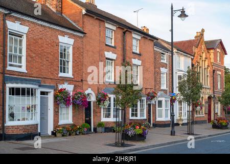 Nei cestini appesi di fiori su fronti di casa nella città di Pershore, Worcestershire, Regno Unito Foto Stock