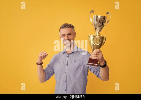 felice uomo di successo tenere la tazza d'oro, motivazione Foto Stock