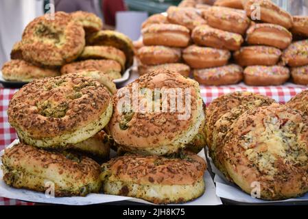 Mostra di cibo con pane alle erbe e ciambelle ghiacciate sullo sfondo Foto Stock