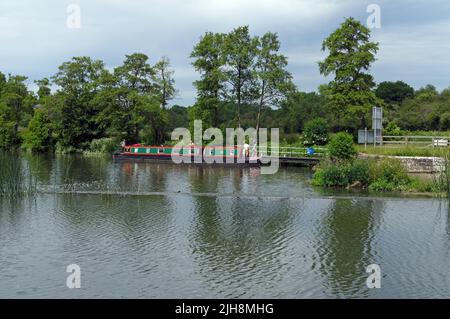 Chiatta del canale / barca stretta che entra nella serratura sul fiume Avon a Saltford, Bristol. Estate 2022. Giugno Foto Stock