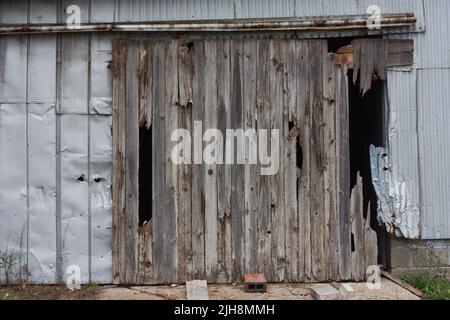 Una vecchia porta fienile che ha visto giorni migliori Foto Stock