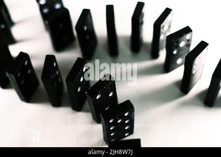 The black dominoes lined up on a white surface Stock Photo