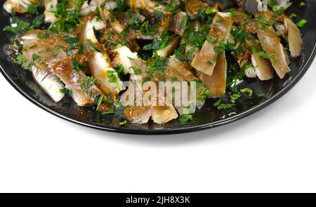 Funghi di ostrica fritti con cipolle e spezie in un piatto isolato su sfondo bianco. Messa a fuoco selettiva. Foto Stock