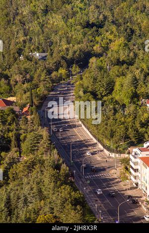 Vista dall'alto della tortuosa autostrada che attraversa la foresta al tramonto Foto Stock