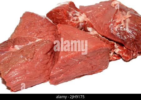 carne fresca di manzo rossa tagliata su fondo bianco, pronta per essere tagliata e tagliata a pezzi e cotta in diverse ricette, fuoco selettivo di crudo Foto Stock