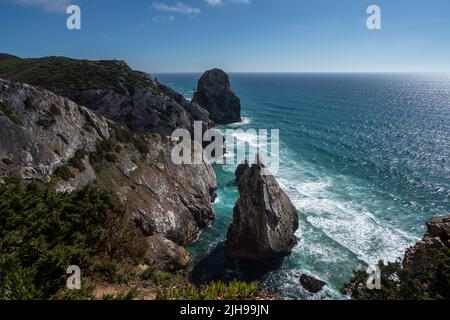 Spettacolari scogliere rocciose a Ursa Beach con onde dell'Oceano Atlantico, Parco naturale di Sintra, Portogallo Foto Stock