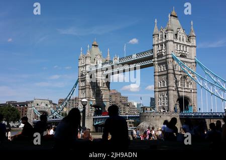 Le sagome delle persone sono viste godendo il caldo tempo nella zona del London Bridge. Il Regno Unito sta abbracciando il clima più caldo mai dovuto all'impatto dei cambiamenti climatici. Si prevede che le temperature aumenteranno a 40 gradi a Londra il lunedì. L'Ufficio MET ha emesso un allarme per le condizioni meteorologiche rosse e ha messo in guardia i cittadini circa il rischio di morte in condizioni di clima caldo estremo. Foto Stock