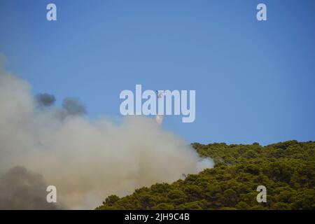 Elicottero d'acqua bombardando il fuoco selvaggio nella Sierra de Mijas. 18 luglio 2022, Mijas, Andalusia, Spagna. Foto Stock