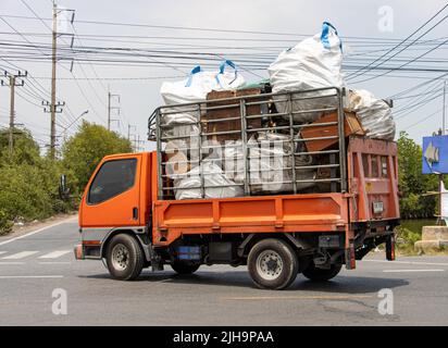 Un camion carico di sacchi grandi e vecchi mobili giro su una strada di campagna Foto Stock