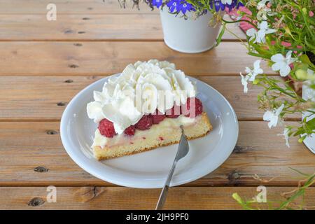 Torta con lamponi freschi e panna montata su un rustico tavolo di legno, dessert di frutta in estate, spazio copia, fuoco selezionato, stretta profondità di campo Foto Stock