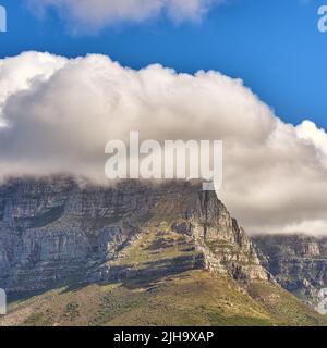 Nuvole che coprono la cima di Table Mountain, Città del Capo con copyspace. Nuvola forma e ombra su terreno roccioso in una giornata di sole, bella, tranquilla natura in Foto Stock