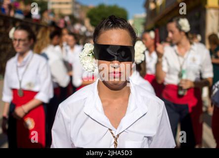 Malaga, Spagna. 17th luglio 2022. Una penitente della fratellanza di Virgen del Carmen, veduta bendata mentre prende parte alla processione nel quartiere 'El Palo'. Ogni anno, il 16 luglio, la città di Malaga celebra una festa religiosa in onore della Vergine del Carmen, patrona di marinai e pescatori. La statua della Vergine, portata da un gruppo di credenti in costume tradizionale lungo le strade, è posta su una barca dalla spiaggia, che più tardi naviga lungo la costa di Malaga. (Foto di Jesus Merida/SOPA Images/Sipa USA) Credit: Sipa USA/Alamy Live News Foto Stock