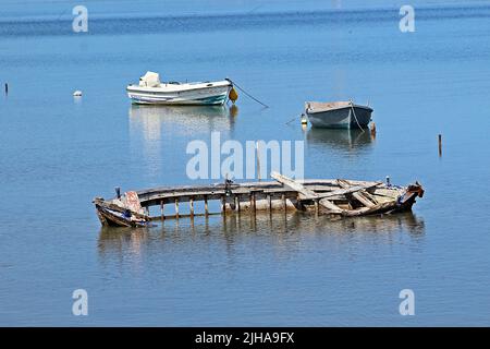 KANONI, CORFU, GRECIA - 13 SETTEMBRE 2017 scheletro marciante di una tradizionale barca a remi in legno in acque blu limpide con barche moderne sullo sfondo Foto Stock