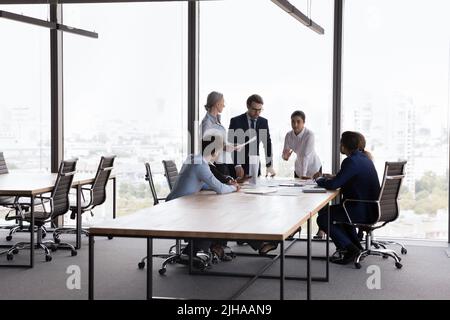 Giovane azienda leader che parla al gruppo di progetto in un ufficio moderno Foto Stock
