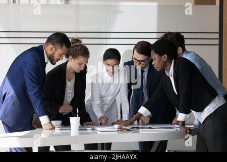 Gruppo di lavoro multietnico millenario di dipendenti che discutono di progetto Foto Stock