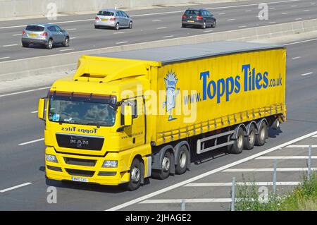 Vista anteriore giallo UOMO hgv negozio consegna camion Topps piastrelle marchio web pubblicità sul lato vista del rimorchio tenda di accesso pieghevole sulla strada autostrada del Regno Unito Foto Stock