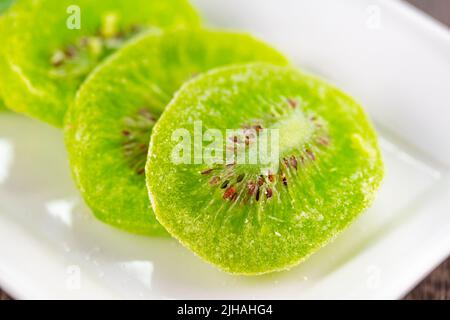 Fette di kiwi essiccato su un piatto bianco Foto Stock