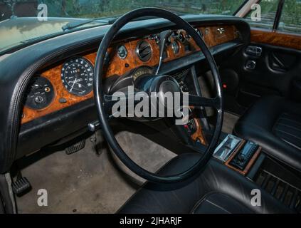 Vista dell'esclusiva limousine di lusso Rolls Royce Silver Shadow 1975 parcheggiata in città. Interno della vettura. Pannelli di controllo, ruota Foto Stock