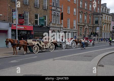 Carrozza trainata da cavalli in attesa di dare ai turisti giri di fronte al Fusiliers Arch, St Stephen's Green, Dublino, Irlanda, luglio 2022 Foto Stock