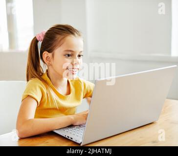 computer portatile bambino tecnologia home ragazza istruzione lavoro bambino apprendimento internet infanzia studente seduta connessione utilizzando online Foto Stock