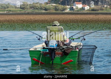 Pescatore nella sua barca sul lago Skadar in Montenegro Foto Stock