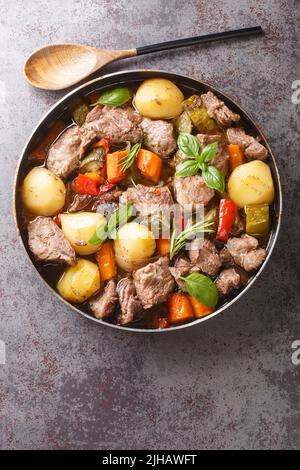 Peka Croatian Meat and Vegetable Stew close-up sul tavolo. Vista dall'alto verticale Foto Stock
