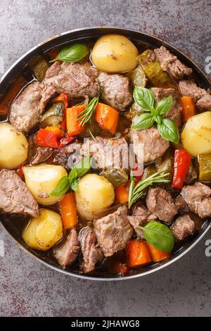 Nazionale croato cibo peka cotto con carne e verdure su un fuoco aperto primo piano sul tavolo. Verticale vista dall'alto Foto Stock