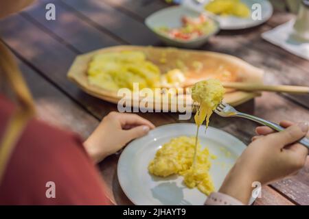 Tradizionale pasto montenegrino. Kacamak in ciotola di legno nella caffetteria all'aperto Foto Stock