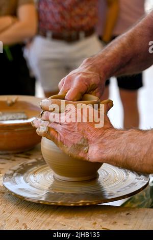 Rodi, Grecia - Maggio 2022: Potter usando le sue mani per modellare un nuovo vaso da argilla usando la ruota di un vasaio Foto Stock