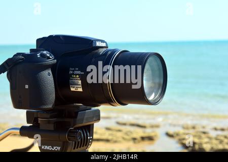 Sinai, Egitto, 23 2018 agosto: Una macchina fotografica digitale Nikon su un treppiede che riprende e registra una scena naturale su una spiaggia del Sinai del Sud di fronte al rosso s Foto Stock