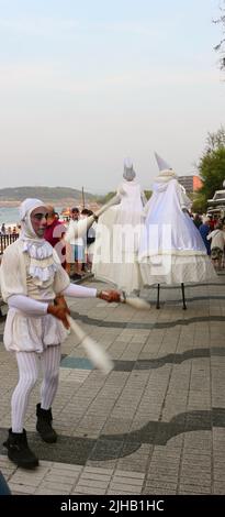 Bambolea circo spettacolo pubblico con un giocoliere e due artisti su palafitte vicino Piquio Santander Cantabria Spagna Foto Stock